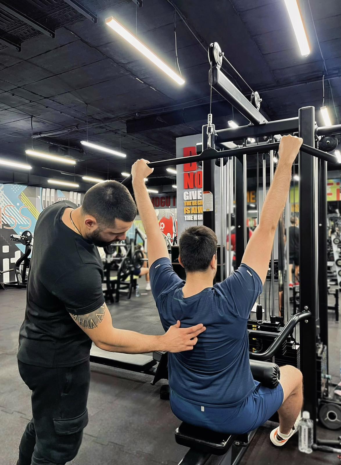 Trening leđa sa personalnim trenerom u modernoj teretani